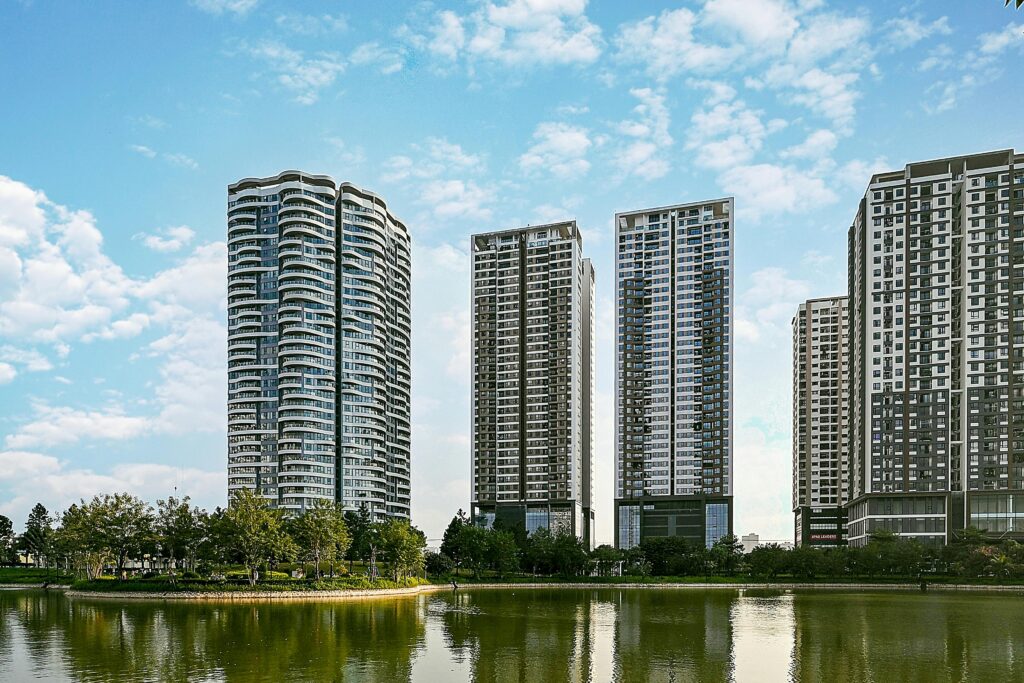 A stunning cityscape view with modern high-rise buildings reflecting on a serene waterfront.